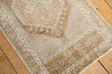 Oushak rug corner, distressed pale bronze latch motif and seafoam meandering border.
