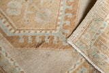 Distressed vintage Oushak rug with low pile, pale bronze pattern, and woven reverse.