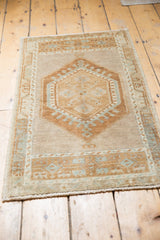 Distressed Oushak rug's bottom border showing low pile, fringe, and pale geometric motifs.