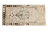 Distressed vintage Oushak rug mat with ivory, seafoam, brown central floral medallion and stepped corners, 1'6