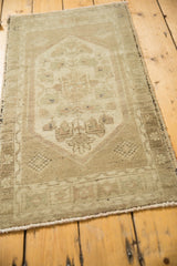 Vintage Oushak rug's low pile featuring blossoming floral motifs and an intricate vine border in beige and ivory.