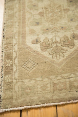 Low pile texture and intricate vine border of vintage Oushak rug in beige and sand.