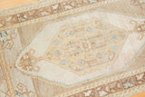 Distressed Oushak rug's ivory central medallion with subtle floral and scrolled leaf patterns.