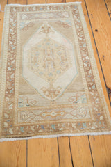 Distressed Oushak rug end, with floral cross sections, serrated outer border, and fringe.