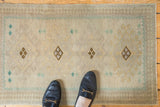 Distressed Vintage Oushak rug mat with even wear, in sand, ivory, and geometric pawn motifs.