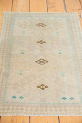 Distressed vintage Oushak rug with ivory and sand geometric relief and even knot wear.