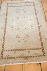 Distressed Oushak runner's lower border and fringe, showing chocolate brown geometric patterns and even wear.