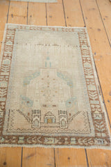 Lower border detail of vintage distressed Oushak rug, showing brown architectural plant motifs and worn pile.