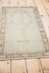 Distressed vintage Oushak rug with soft texture, pale bronze geometric border, and light fringe.