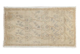 Distressed vintage Oushak rug with allover floral palmettes in ivory, sand, and pale seafoam green.