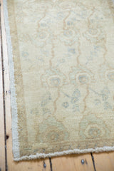 Distressed texture and ivory, sand, seafoam green floral palmette pattern on vintage Oushak rug.