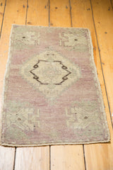 Vintage Oushak rug's distressed pale mauve field and serrated ivory medallion.