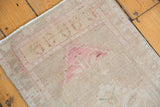 Distressed ivory Oushak rug corner showing faded blush rose patterns and original side selvage.