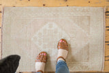 Distressed vintage Oushak rug mat with even wear and softly faded patterns.