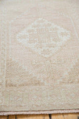 Vintage distressed Oushak rug, soft ivory beige pile with even wear.