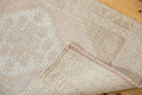 Distressed vintage Oushak rug showing soft pile, hand-knotted reverse, and intact selvage.