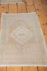 Distressed Turkish Oushak rug detail with even wear, faded medallion pattern, and muted ivory beige tones.