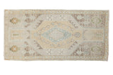 Vintage distressed Oushak mat with sand and aqua diamond medallion, floral vinery.