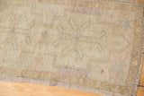 Distressed vintage Oushak rug texture in sand, ivory, and beige with faded primitive motifs.