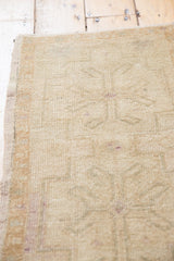 Distressed pile texture and faded primitive ram's horn motifs on vintage Oushak rug.