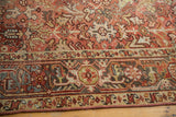 Distressed Heriz carpet border detail, geometric slate blue and red patterns, showing knot wear.