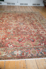 Worn geometric floral palmettes in tomato red and green on a vintage distressed Heriz carpet.