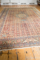 Distressed Bijar carpet's brick red, blue, green border patterns, and creamy white fringe.