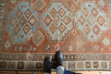 Distressed vintage Afshar rug section showing faded sky blue and brick red geometric motifs.