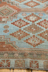 Muted sky blue field and brick red guls on a distressed vintage Afshar rug border.