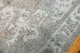 Textured distressed Sivas carpet showing faded curvilinear motifs in ivory, charcoal, and teal.