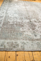 Distressed vintage Sivas carpet showing worn pile texture, ivory, gray, dusty bronze, and teal hints.