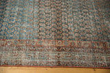 Distressed texture of vintage Serbend runner with abrashed blues and brick red border.