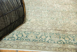 Distinct teal floral border on a distressed vintage Tabriz carpet's worn ivory field.