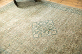 Vintage Tabriz rug with distressed ivory, sand, and teal Herati pattern showing wear.