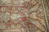 Distressed vintage Mahal rug texture, showing raspberry red, sea foam green floral patterns and even wear to knot heads.