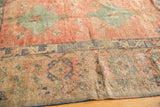 Faded emerald diamond and blue border motifs on a distressed vintage Oushak rug.
