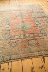 Distressed low pile and securing end fringes of a vintage Oushak rug.