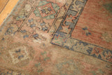 Abrashed dusty blush and royal blue patterns on a distressed vintage Oushak rug corner.