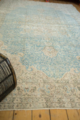 Distressed vintage Sivas carpet, light blue, beige vinery, with visible foundation wear.