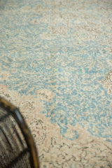 Faded sky blue and antique ivory scrolling vinery on the distressed Sivas carpet pile.