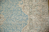 Distressed vintage Sivas carpet, faded blue and beige scrolling vinery, foundation showing.