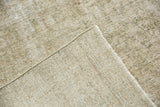 Secured side and hand-knotted foundation, with textured, worn ivory, sand, and moss green pile.