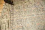 Distressed Khotan rug pile shows exposed foundation, muted slate gray, apricot motifs.