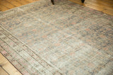 Distressed Khotan rug with mostly even wear, faded apricot, blush, and slate gray.