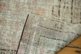 Distressed Khotan rug with visible hand knotted foundation and heavily worn pile.