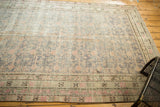 Vintage distressed Khotan runner, showing muted pomegranate motifs, slate, apricot, and visible foundation wear.