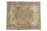 Distressed vintage Heriz carpet with faded geometric medallion, coffee brown, ivory, and muted blue.