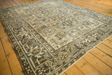 Distressed vintage Heriz carpet detail with geometric field, turtle/samovar border, and ivory, brown tones.