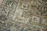 Geometric stylization and distressed texture in brown, ivory, and charcoal on a vintage Heriz carpet.