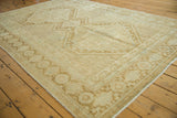 Afshar carpet detail: distressed intricate patterns in sand, ivory, and faded copper.